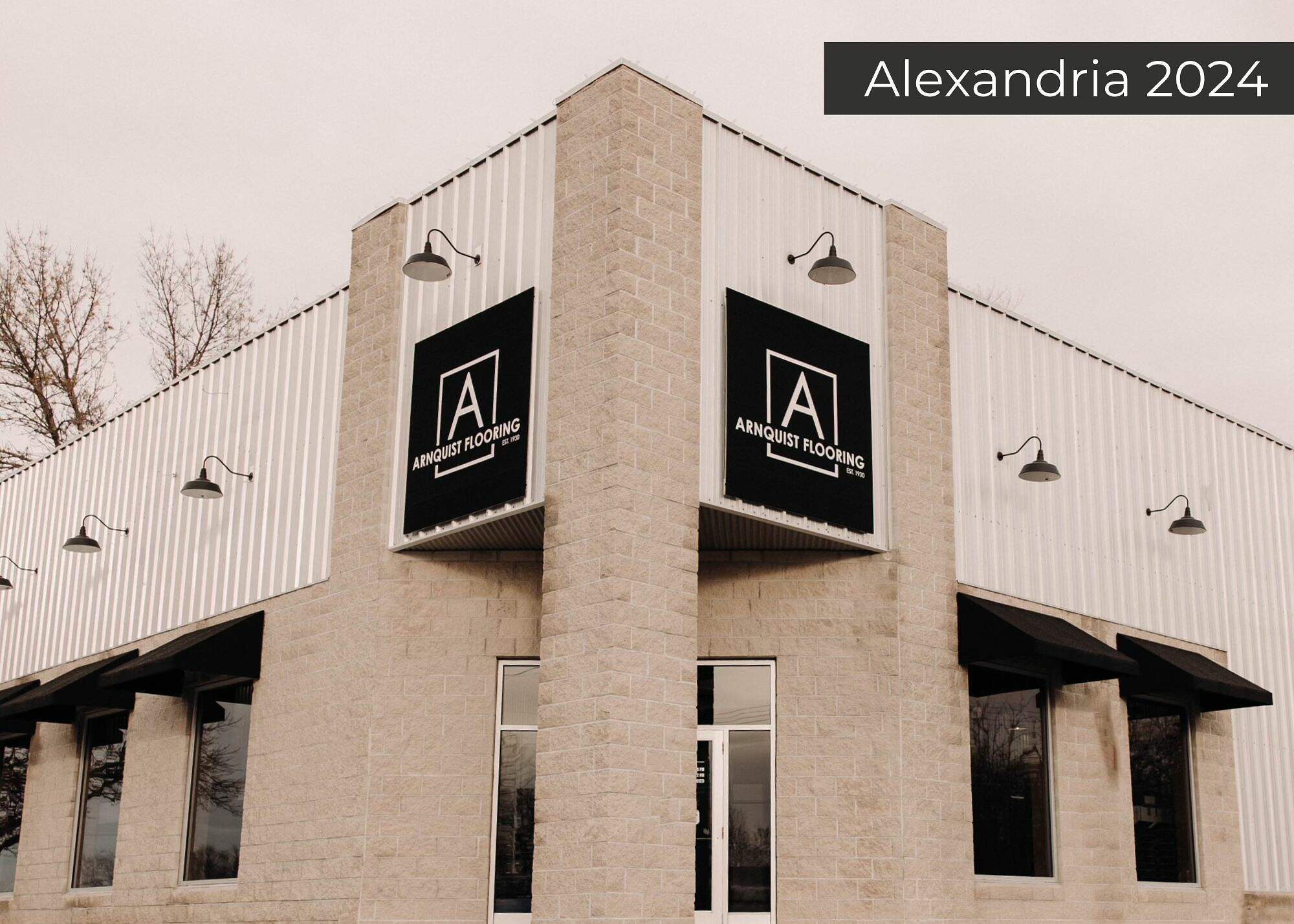 Modern commercial building with a corrugated metal facade, featuring two prominent signs for 'Alexandria Roofing', captured on a cloudy day—anticipating business growth in 2024.