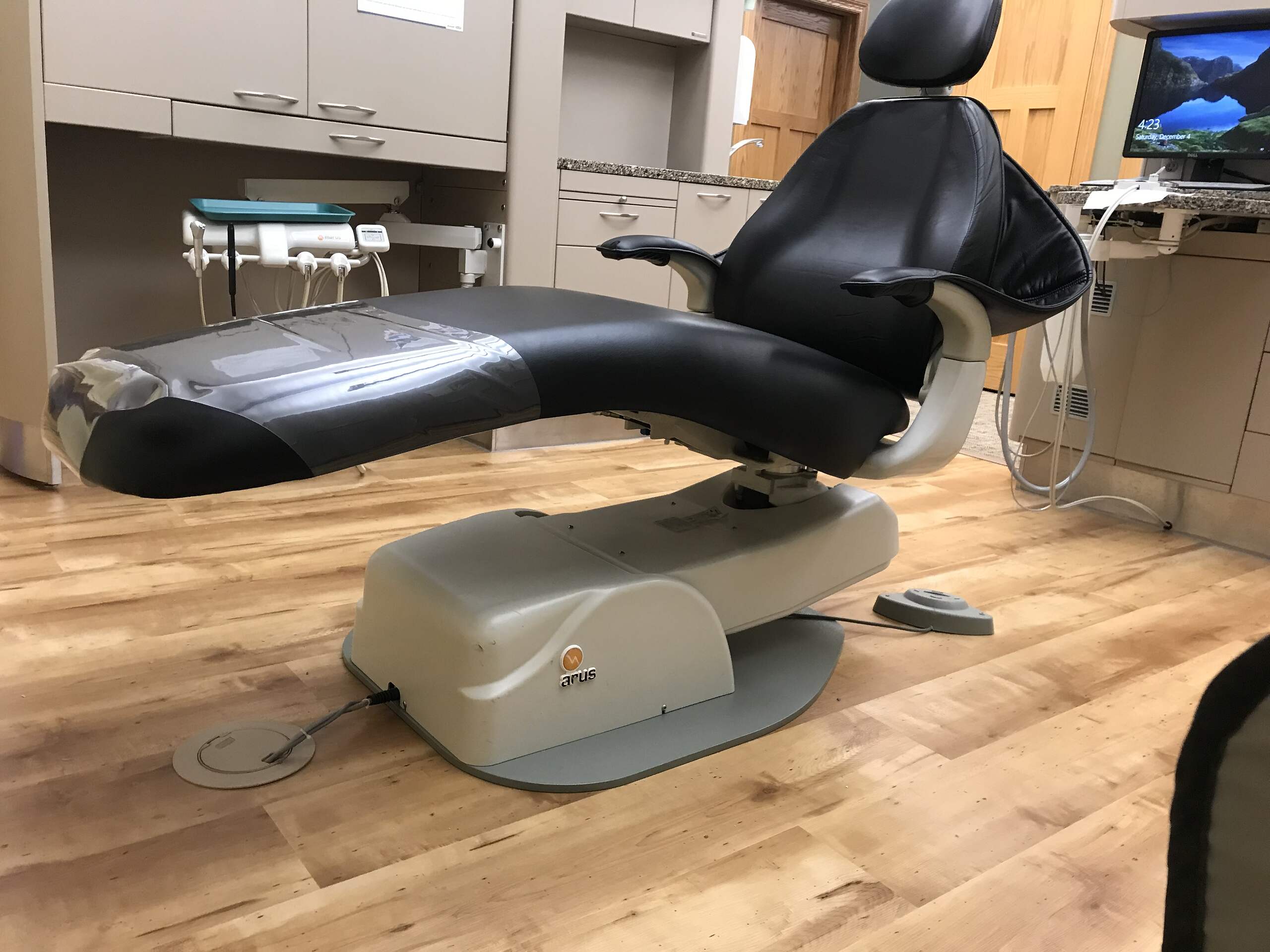 A modern dental chair with dentistry equipment in an examination room, ready for the next patient.